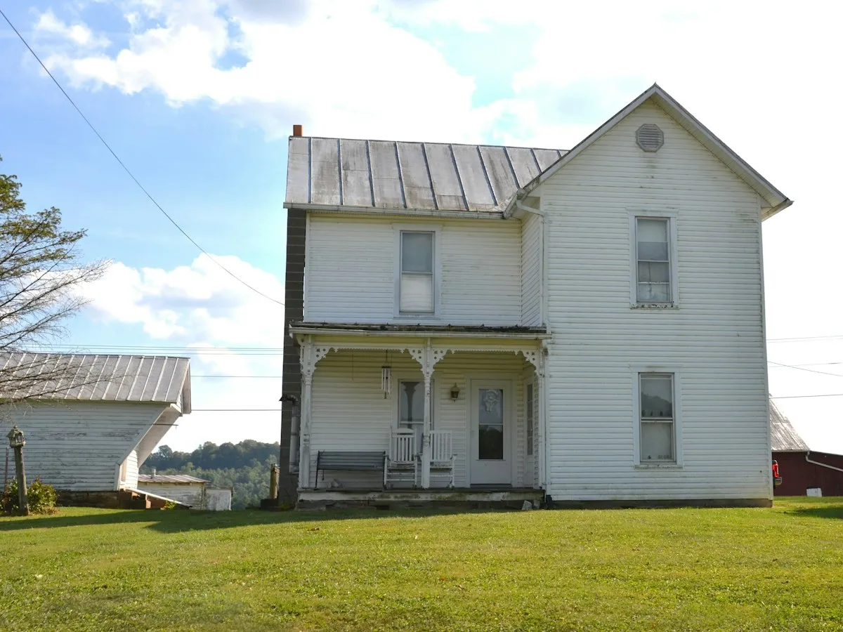 White two-story farmhouse with a covered porch